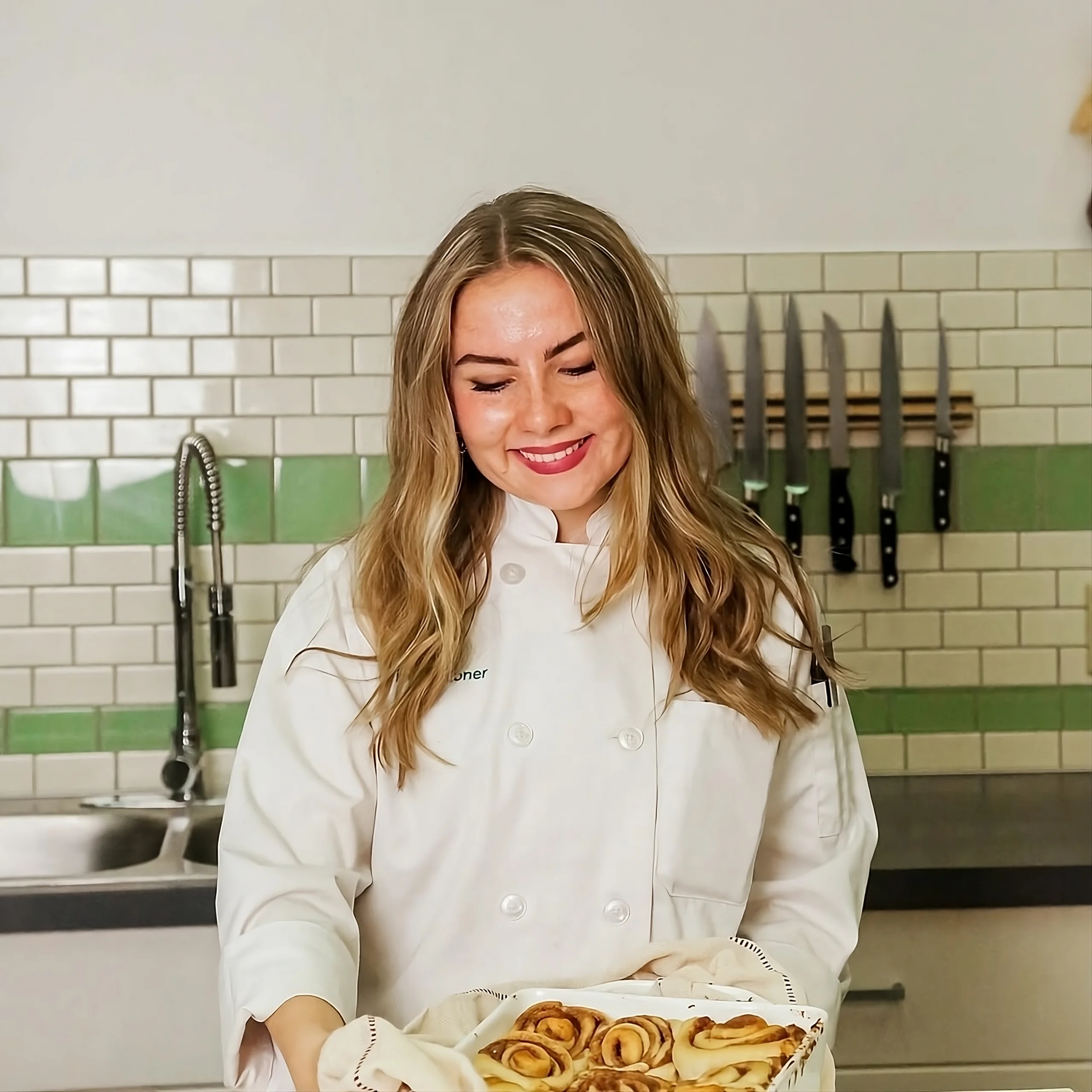 Learning Simple Homemade Food Nora holding cinnamon rolls, representing her early passion for simple home cooking.